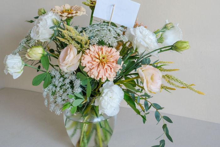 Standard floral delivery of light pink flowers in a clear glass vase